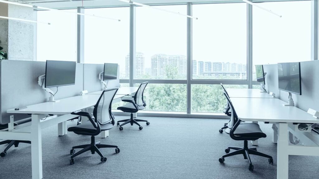 Bright and spacious NEARSOL office setup for white-label customer service teams, featuring minimalist workstations, ergonomic chairs, and large windows overlooking a city skyline.